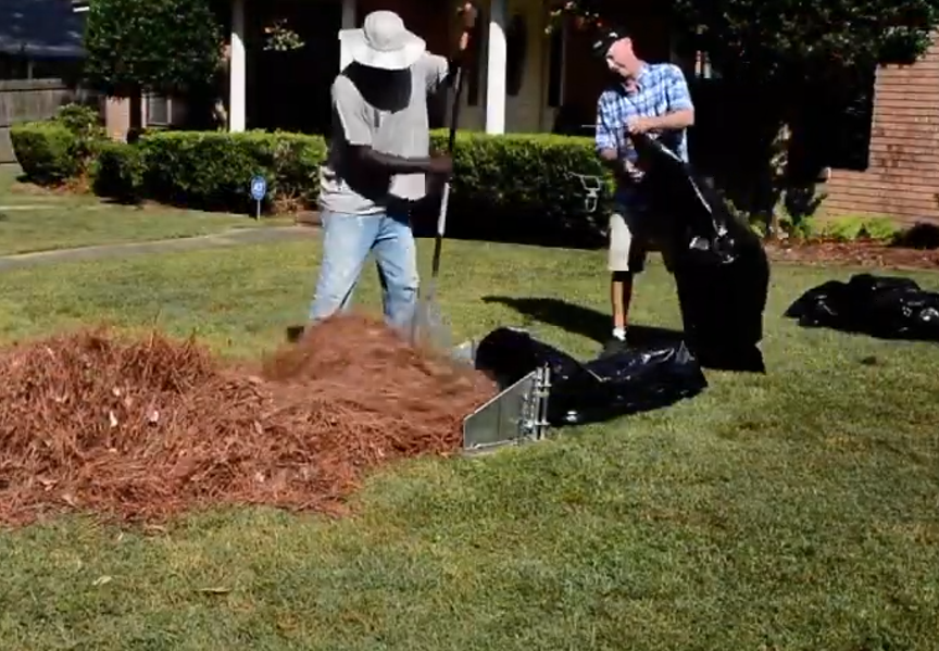 Two men collecting debris.